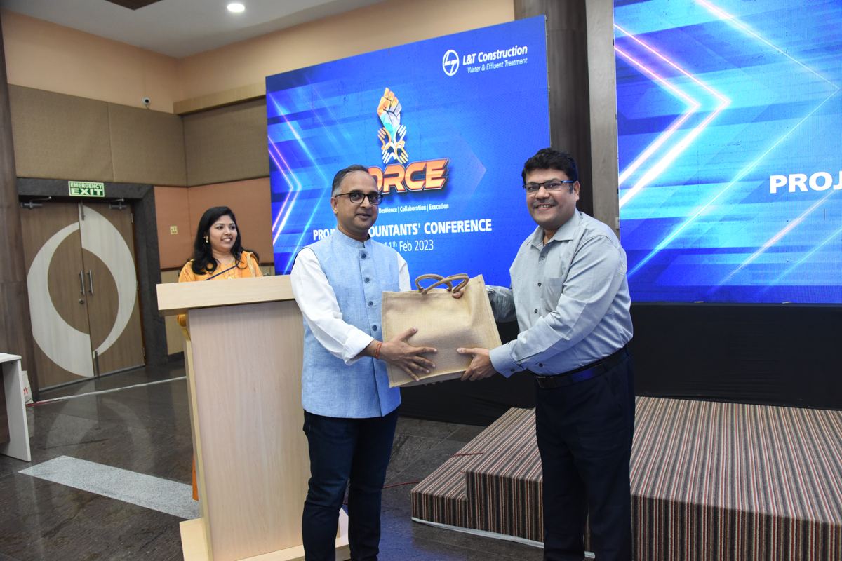 Kamlesh Jain being thanked on stage at a conference