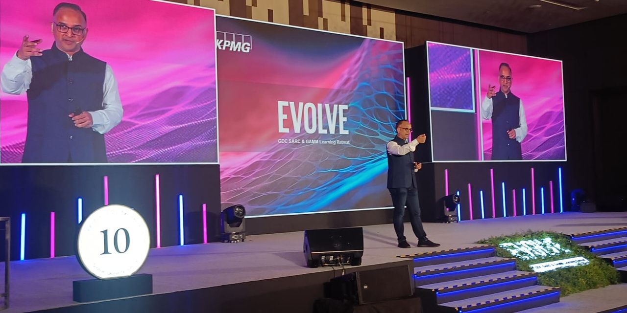 Kamlesh Jain on stage before a large audience