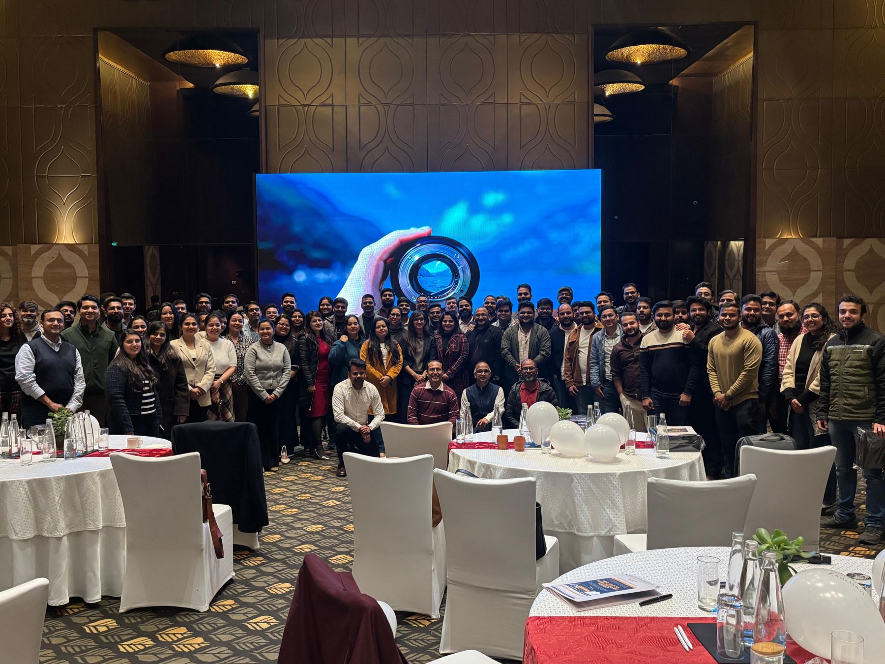 Kamlesh Jain with a ballroom full of PACT participants in front of a large screen